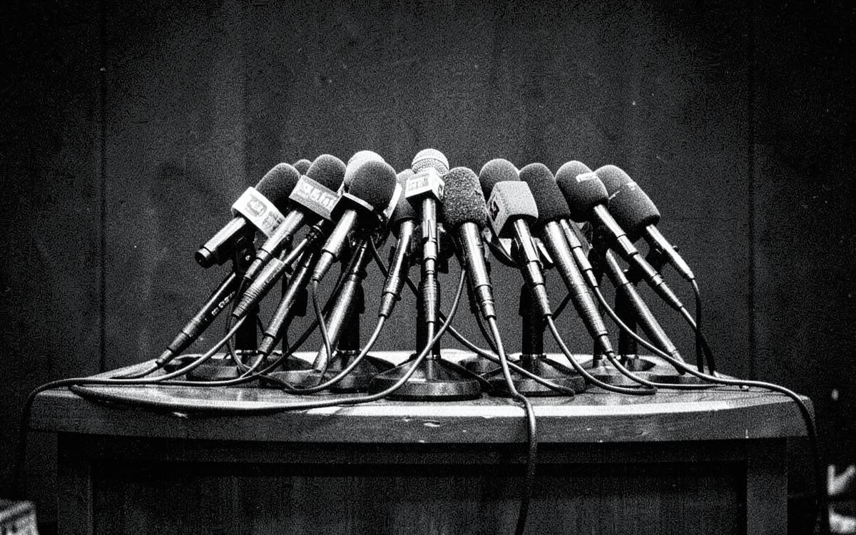 A cluster of press microphones on an empty podium